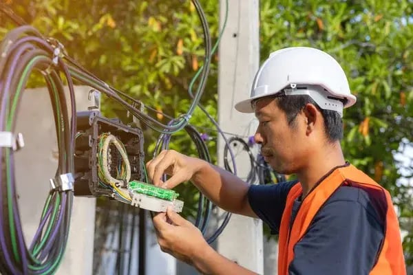 depositphotos_609775080-stock-photo-engineer-repair-connector-fibers-splitter